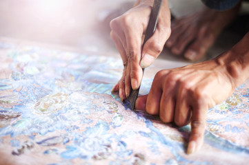 Vietnamese craftsman carving out and painting a floral pattern
