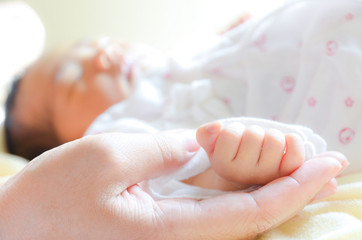 Mother holding newborn baby's hand