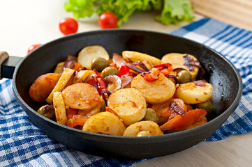 Baked potato with vegetables in a frying pan