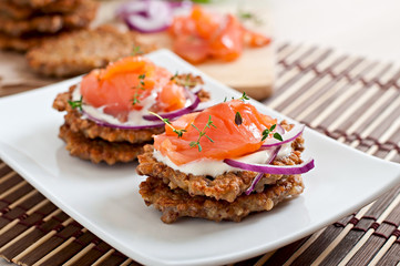 Buckwheat pancakes with salted salmon and sour cream close up