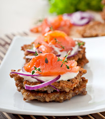 Buckwheat pancakes with salted salmon and sour cream close up