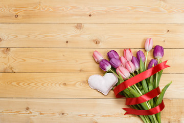 Fototapeta na wymiar Tulips on wooden texture