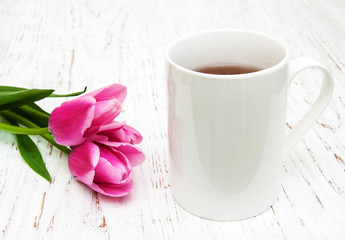 Obraz na płótnie Canvas Cup of tea and pink tulips