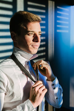Man Adjusting The Tie