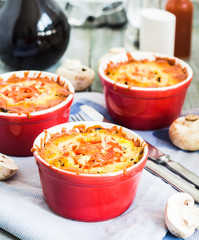 mushroom julienne with tomato and cheese in red pots
