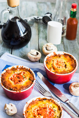 mushroom julienne with tomato and cheese in red pots