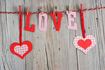 Word LOVE and hearts on old wooden background