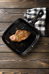 Beef steak on grill pan on a wooden table top view