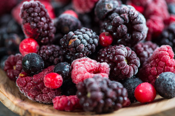 mixed frozen berries on wooden background