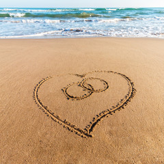 Fototapeta na wymiar Drawing heart on the sand