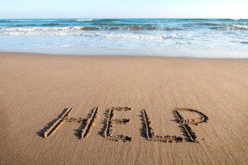 Fototapeta na wymiar Drawing HELP on the sand