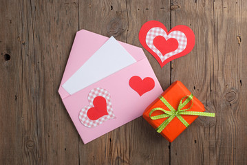 Love letter with gift on old wooden background
