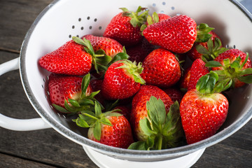 Sweet ripe strawberries in rustic colander