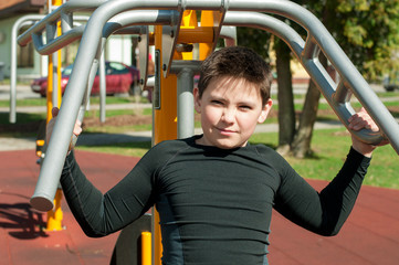 The boy on outdoor sport ground / gym
