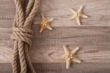 Fototapeta na wymiar rope, starfish on the old wooden background
