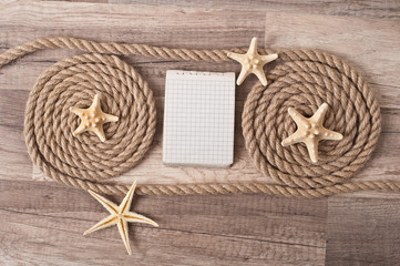 paper, rope, starfish on the old wooden background