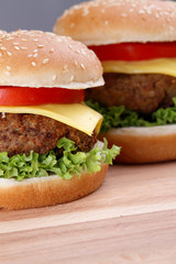 Hamburger with grilled meat and cheese on a wooden surface 

