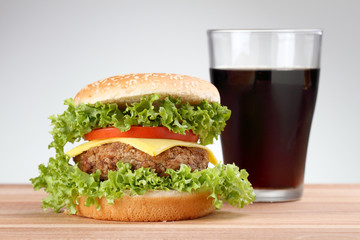 Hamburger with grilled meat and cheese on a wooden surface 

