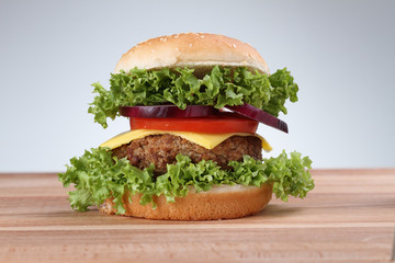 Hamburger with grilled meat and cheese on a wooden surface 

