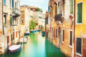 Fototapeta na wymiar Narrow canal with historic buildings in Venice Italy