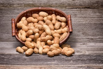 peanuts in basket on old wood background