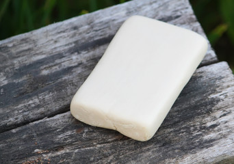 A piece of white soap on a wooden surface