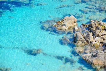 Fototapeta na wymiar grey rocks in Capo Testa clear water