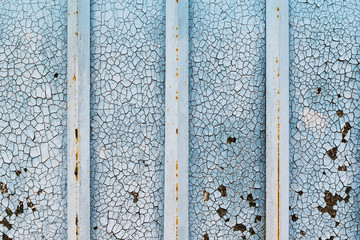 Cracked blue acrylic paint on a wooden surface