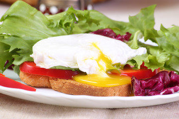 Poached egg with toast and salad, close-up