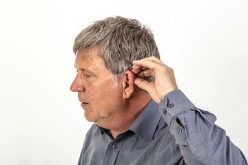 Obraz premium man puts hearing aid in the ear