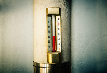 Old vintage thermometer in house heating system.