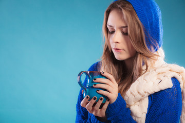 teen girl holding blue mug with hot drink