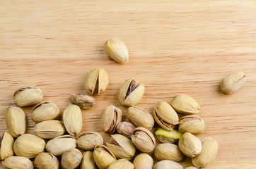 roasted and salted pistachios on wooden background