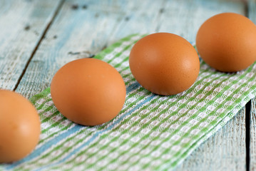 Eggs and dish towel on old wooden table