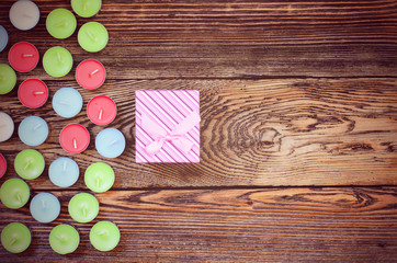 Gift box with candles on wooden table