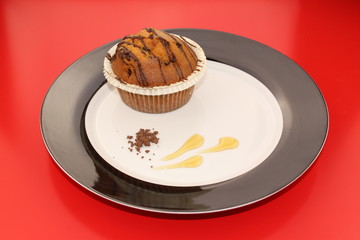 Isolated chocolate muffin decorated with cocoa powder and honey