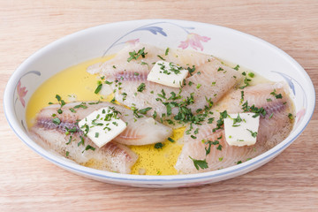 Fresh raw fish with butter, olive oil, lemon juice, herbs and