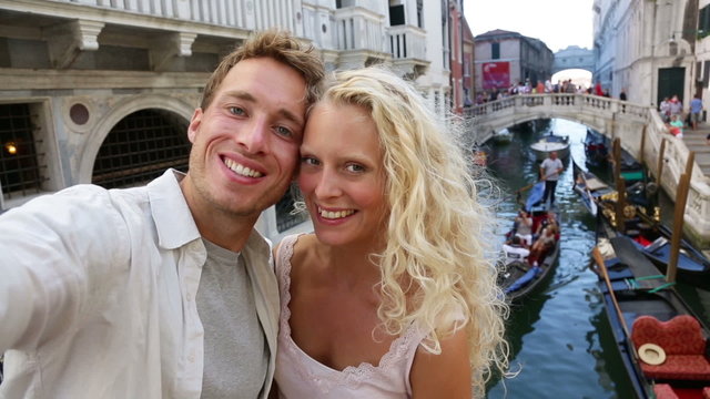 Venice couple taking selfie photo by Canal, Italy