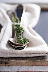 Vintage spoons and thyme on a napkin