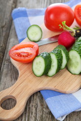 Cucumbers and tomatoes on a cutting board