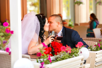 Bride and groom drinking coffee at an outdoor cafe