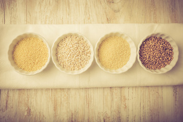 Types of grain groats on a white wood. Vintage photo