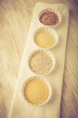 Types of grain groats on a white wood. Vintage photo