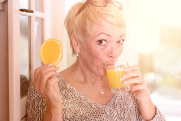 Rentnerin trinkt Orangensaft
