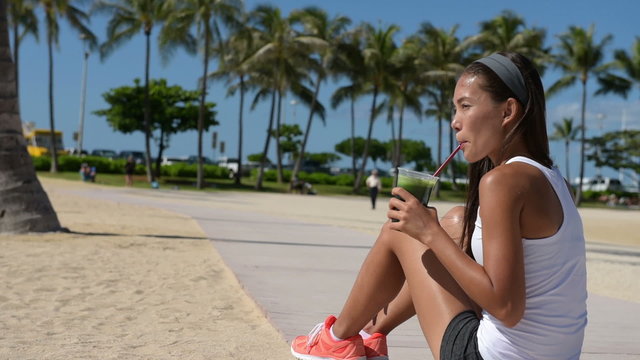 Fit Woman Resting Drinking Green Juice in Workout