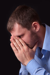 Thoughtful young man in blue shirt