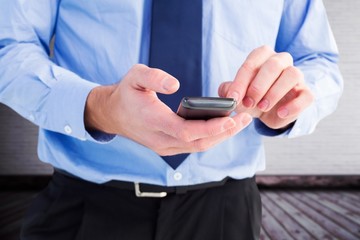 Composite image of close up of a businessman using a smartphone