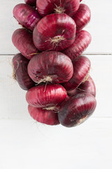 Dangling bunch of sweet red onion.