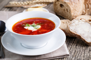 Tasty soup with bread on a wooden background.