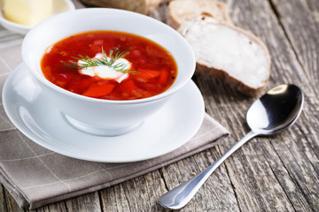 Tasty soup with bread on a wooden background.